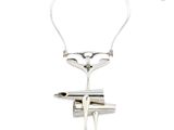 silver plated necklace with a pair of scissors attached to it ' s neck