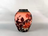un vase orné d'un motif floral sur une surface blanche