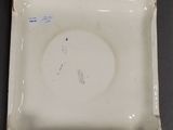 a close up of a white plate on a table with a black background