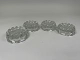 four clear glass dishes on a white table with a white background