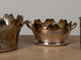 three silver vases sitting on a table next to each other