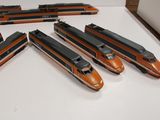 several model trains are lined up on a table in a room