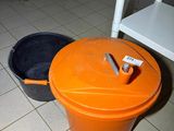 two buckets sitting on the floor next to each other