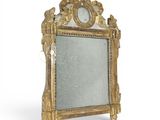 un miroir posé sur un pied, sur une surface blanche