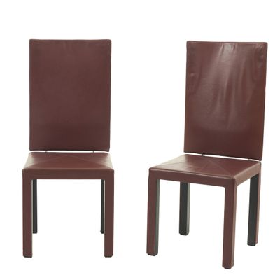 une paire de chaises de salle à manger en cuir marron avec des pieds en métal, sur fond blanc