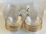 four clear glasses with gold rims sitting on a table