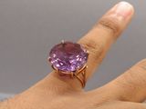 someone is holding a ring with an amethorate stone in it
