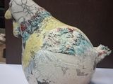 a ceramic sculpture of a chicken sitting on a table