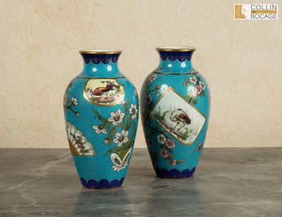 two vases sitting on a table with a wall in the background