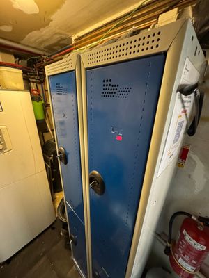 two blue lockers in a room with a fire extinguisher