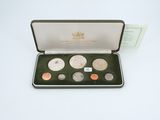 a box of coins sitting on top of a table next to a card