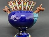 a blue vase that has a crown on top of it