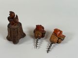 three small figurines sitting on top of a tree stump