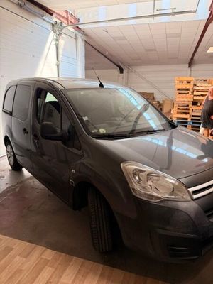 grey van parked in a garage with a man standing next to it