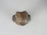 a small figurine of a turtle on a white surface