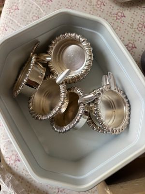 quatre plats en argent dans un saladier posé sur une table