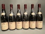 six bottles of wine are lined up in a row on a table