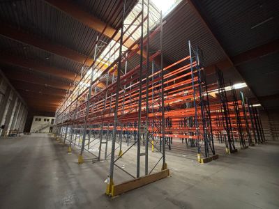 un grand entrepôt rempli d'étagères et de palettes