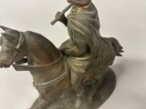 bronze statue of a man riding a horse with a flute in his mouth