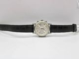 a close up of a watch on a black strap on a white surface