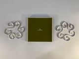 a green box with a green lid sitting next to a pair of silver earrings