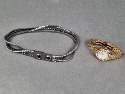 SWAROWSKI. Lot comprenant : 1 montre de dame en métal doré e…