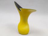 a yellow vase with a black top on a white background