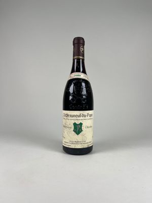 une vieille bouteille de vin posée sur une table blanche