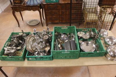 Plusieurs plateaux d'argenterie sont posés sur une table dans une pièce
