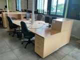 a desk with two computers and two chairs in an office