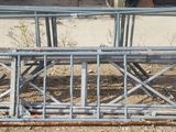a pile of metal pipes sitting in the dirt
