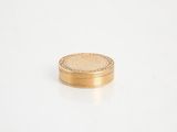 gros plan d'une pièce d'or sur une surface blanche