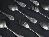 a lot of silver spoons and forks on a table