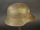 an old military helmet on a stand against a black background