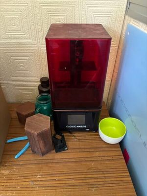 a red 3d printer sitting on top of a wooden table