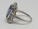 une image d'une bague avec une pierre bleue entourée de diamants