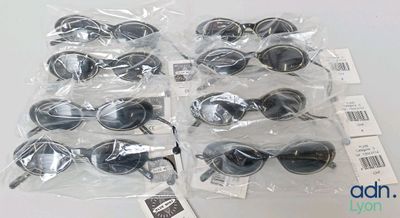 several pairs of sunglasses are wrapped in plastic bags on a table