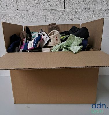 une boîte en carton remplie de vêtements et d'une paire de chaussures