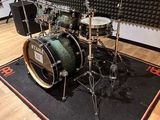 a drum set that is sitting on a rug in a room