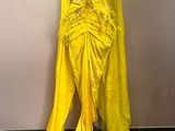 a yellow dress on a mannequin stand in a room