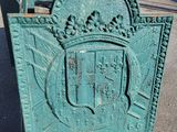 a green sign that has a coat of arms on it