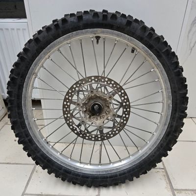 a motorcycle wheel that is sitting on a tile floor