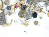 a pile of assorted jewelry on a white surface
