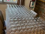 many empty wine glasses lined up on a table