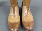 pair of men ' s brown leather shoes on a gray surface