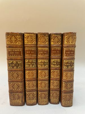 un ensemble de cinq livres anciens avec couvertures en cuir doré et brun