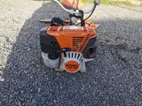 an orange and black lawn mower sitting on the ground