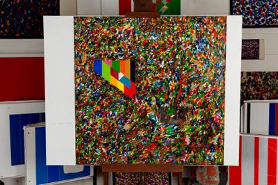 a picture of a painting on a easel with a lot of confetti sprinkles on it