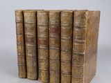 cinq vieux livres sont empilés les uns sur les autres sur une table