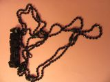 un collier noir orné d'un train, posé sur une table